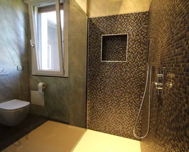 Zona doccia con finiture materiche